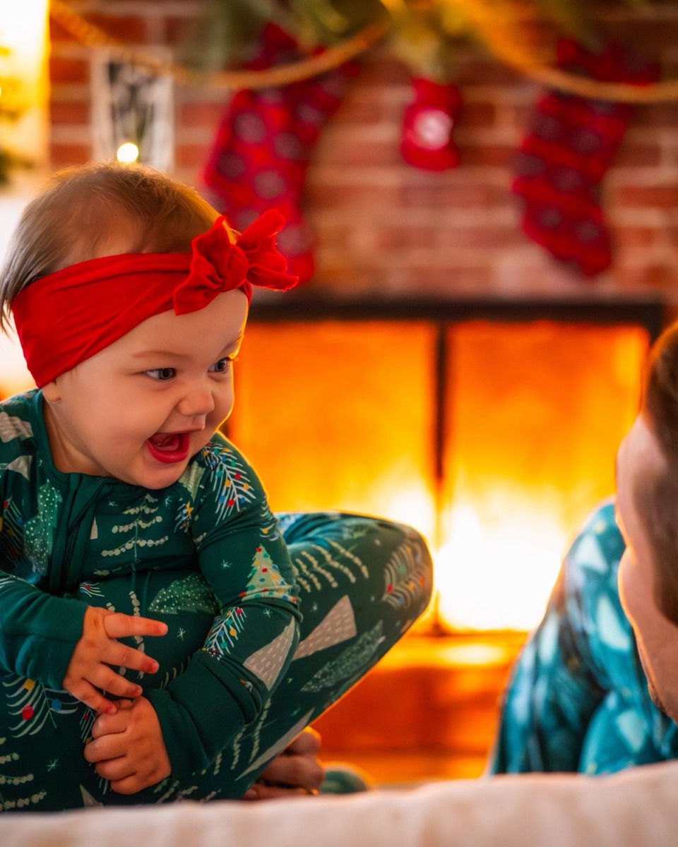 Toddler giggling between two parents' shoulders