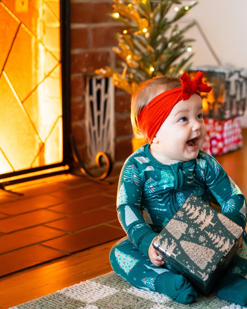 Toddler sitting alone exploring a wrapped gift box